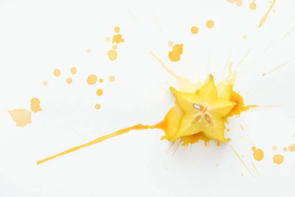 黄色の絵の具と白い面で甘いスター フルーツの高い概観をはねかける  — 無料ストックフォト