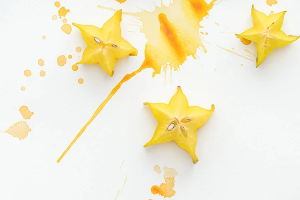 Top View Three Star Fruits White Surface Yellow Paint Splashes — Stock Photo, Image