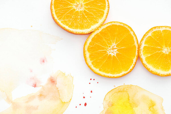 top view of citrus pieces on white surface with yellow watercolor