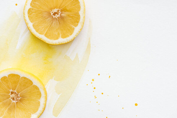 top view of yummy lemon pieces on white surface with yellow watercolor