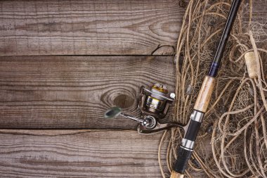top view of fishing net and fishing rod on wooden planks  clipart