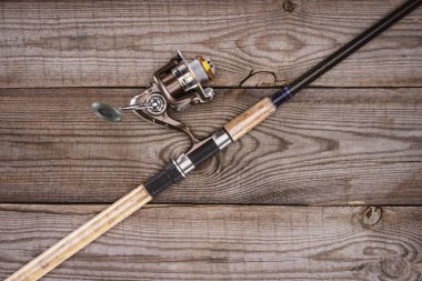 elevated view of fishing rod on wooden background, minimalistic concept  clipart