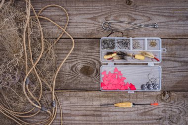 Balık tutma malzemeleri ve kanca ahşap arka plan üzerinde net ve plastik kutusu balıkçılık yükseltilmiş görünümü 