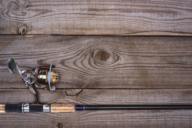 top view of fishing rod on wooden planks, minimalistic concept  clipart
