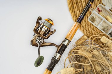 top view of fishing rod, nautical rope and plastic box with fishing tackle and bait isolated on white clipart