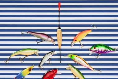 view from above of various fishing float surrounded by bait on striped background  clipart