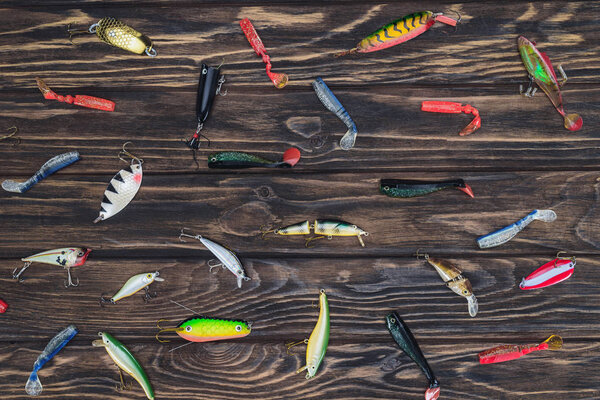 elevated view of arranged various fishing bait on wooden background 