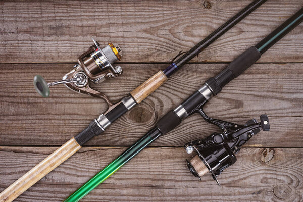 top view of fishing rods on wooden background, minimalistic concept 