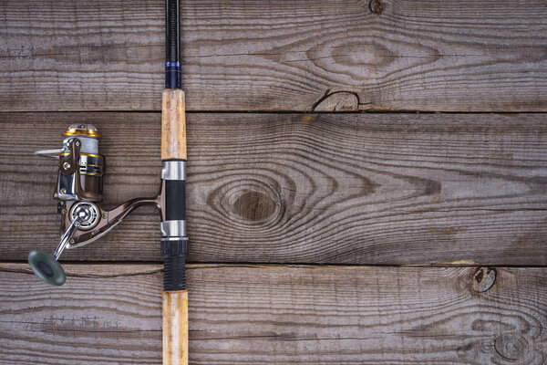 view from above of fishing rod on wooden planks, minimalistic concept 