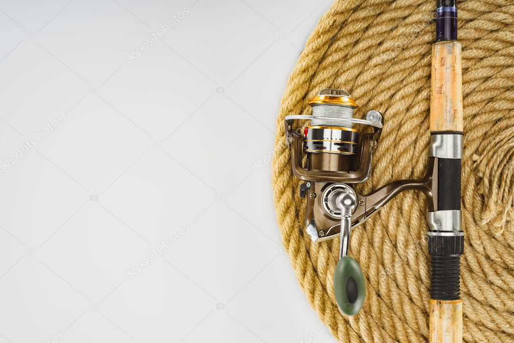 top view of fishing rod and nautical rope isolated on white, minimalistic concept 