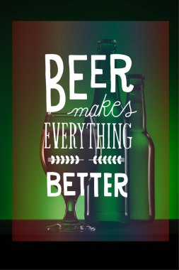 bottles and glass of beer on dark green background with 