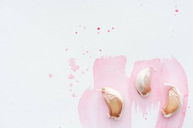 pembe sulu boya darbeleri ile beyaz yüzey üzerinde baharatlı sarımsak üstten görünüm