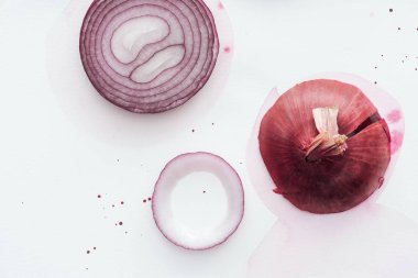çiğ bütün kırmızı soğan Slice üstten görünüm pembe sulu boya lekesi ile beyaz yüzeyi