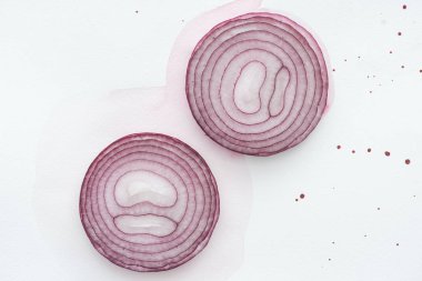 top view of two slices of red onion on white surface with pink watercolor blots clipart