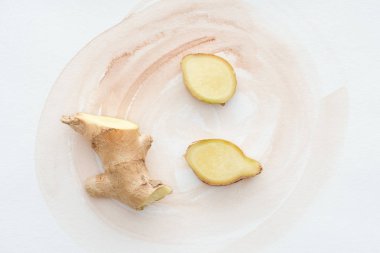 top view of sliced ginger root on white surface with watercolor strokes clipart