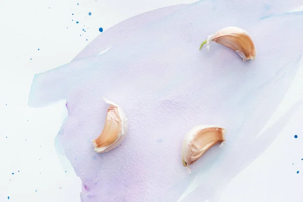 Top View Pieces Spicy Garlic White Surface Purple Watercolor Strokes — Free Stock Photo