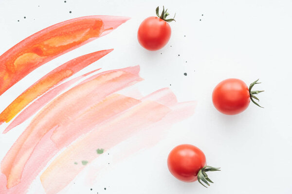 top view of delicious cherry tomatoes on white surface with red watercolor strokes