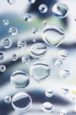 close-up view of beautiful transparent water drops on light blurred background clipart