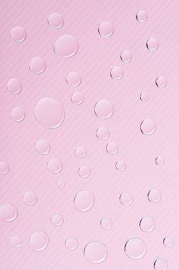 close-up view of transparent water drops on pink background clipart