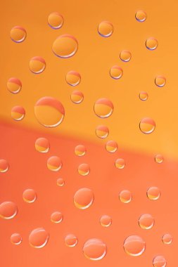 close-up view of transparent calm water drops on orange background             clipart