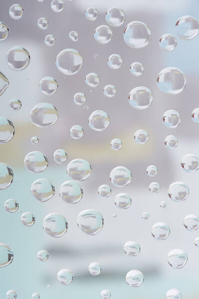 close-up view of beautiful transparent water drops on blurred abstract background