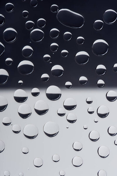 close-up view of transparent water drops on grey abstract background 