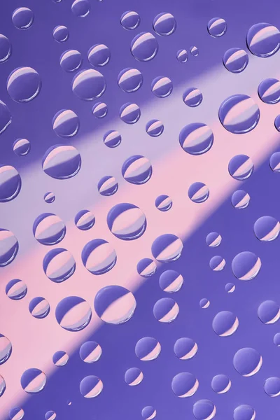 Vergrote Weergave Van Transparant Water Druppels Roze Violet Achtergrond — Gratis stockfoto