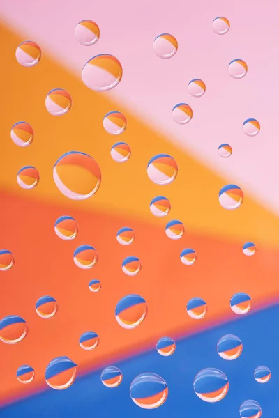 Vergrote Weergave Van Transparante Kalm Water Druppels Kleurrijke Achtergrond — Gratis stockfoto
