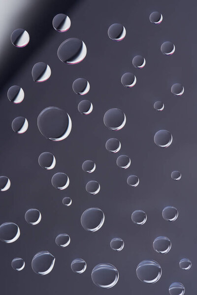 close-up view of transparent calm droplets on grey background    
