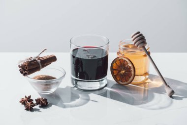 Cam, tarçın ve bal beyaz masa üzerinde mulled şarap