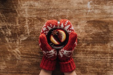 mittens mulled şarap cam ahşap masa üstü, Noel kavramı holding içinde kadın kırpılmış görüntü