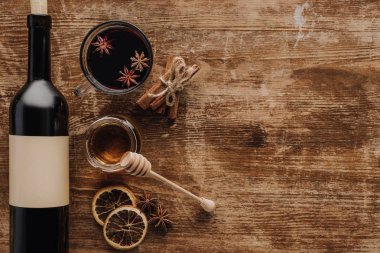 ahşap masa üzerinde mulled şarap, bal ve şarap şişesi yükseltilmiş görünümü