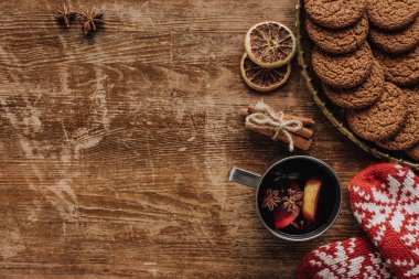 top view of mulled wine in cup, mittens and cookies on wooden tabletop, christmas concept clipart