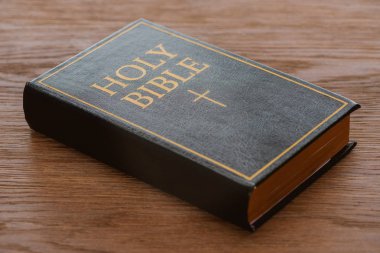 close-up shot of holy bible lying on wooden surface clipart