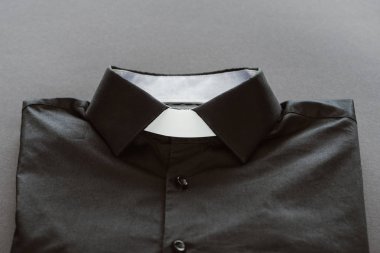 close-up shot of clerical shirt with white collar on grey surface clipart