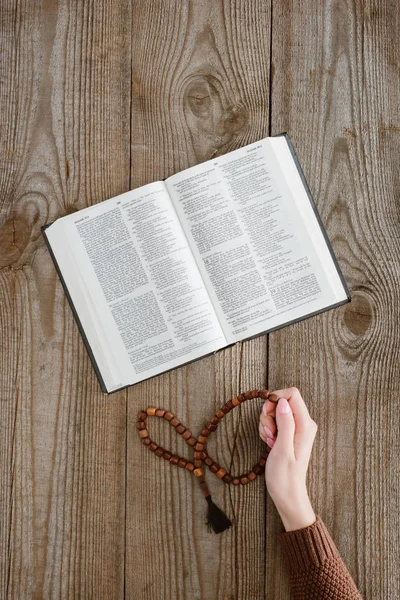 Tiro Cortado Mulher Com Bíblia Sagrada Segurando Grânulos Mesa Madeira — Fotografia de Stock