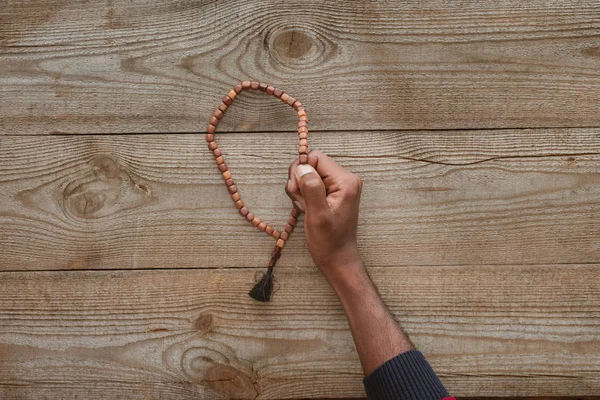 Cropped Shot African American Man Holding Beads Wooden Table — Stock Photo, Image