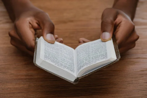 Cortado Tiro Homem Afro Americano Lendo Bíblia Sagrada Mesa Madeira — Fotografia de Stock