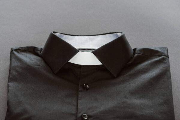 close-up shot of clerical shirt with white collar on grey surface
