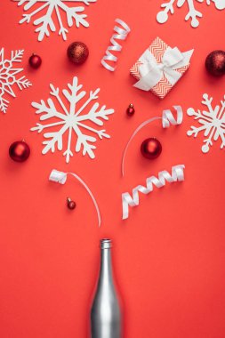 üstten görünüm kırmızı izole kırmızı Noel oyuncaklar, beyaz kurdeleler ve dekoratif kar taneleri düzenlenmiş mevcut, gümüş şişe