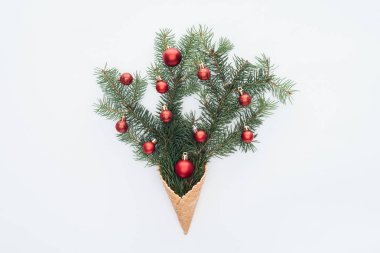 çam ağacı dalları üzerinde beyaz izole dondurma koni üzerinde kırmızı Noel oyuncaklar üstten görünüm