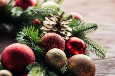 çam ağacı çelenk kırmızı ve altın Noel topları ile bakış ahşap arka plan üzerinde kapatın