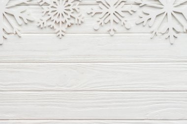 flat lay with decorative snowflakes on white wooden tabletop clipart