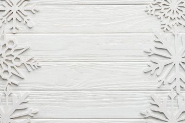 flat lay with decorative snowflakes on white wooden tabletop clipart