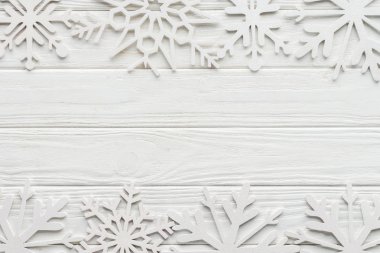 flat lay with decorative snowflakes on white wooden tabletop clipart