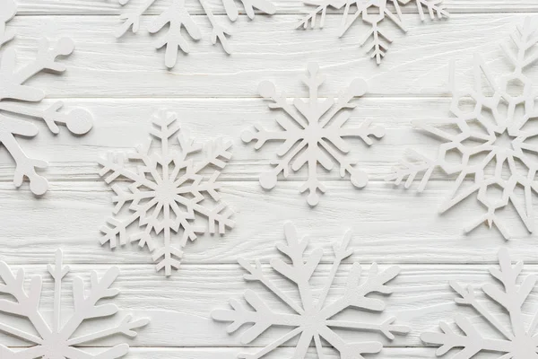 Επίπεδη Lay Διακοσμητικές Νιφάδες Χιονιού Στο Άσπρο Ξύλινες Επιτραπέζια — Φωτογραφία Αρχείου