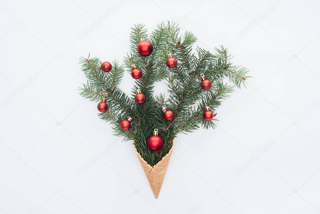 top view of red christmas toys on pine tree branches in ice cream cone isolated on white