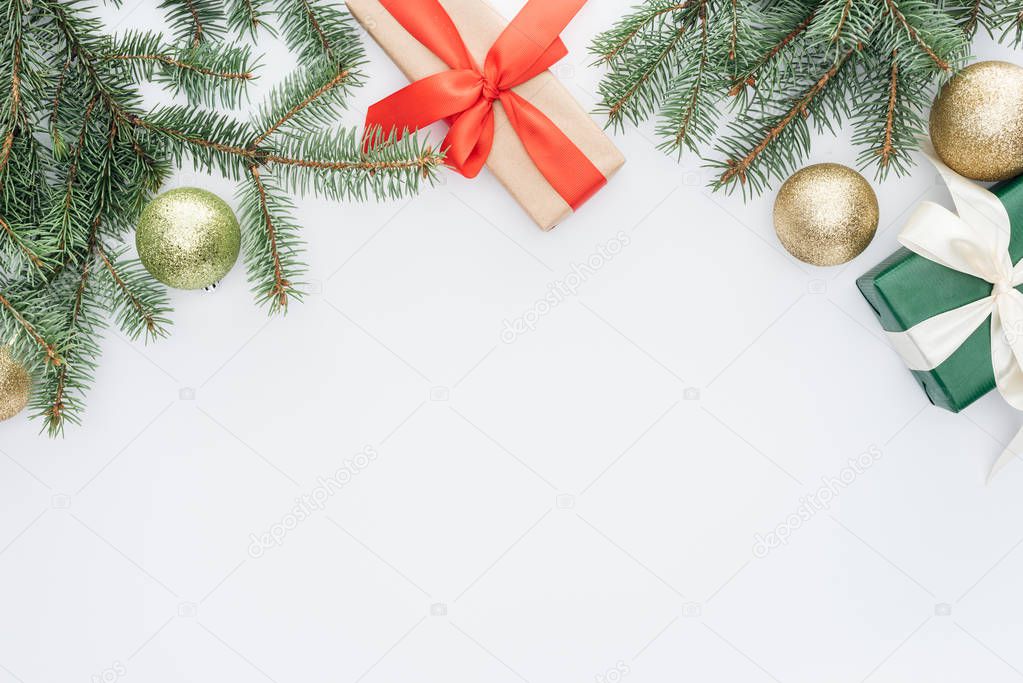 flat lay with arranged pine tree branches, gifts and christmas toys isolated on white