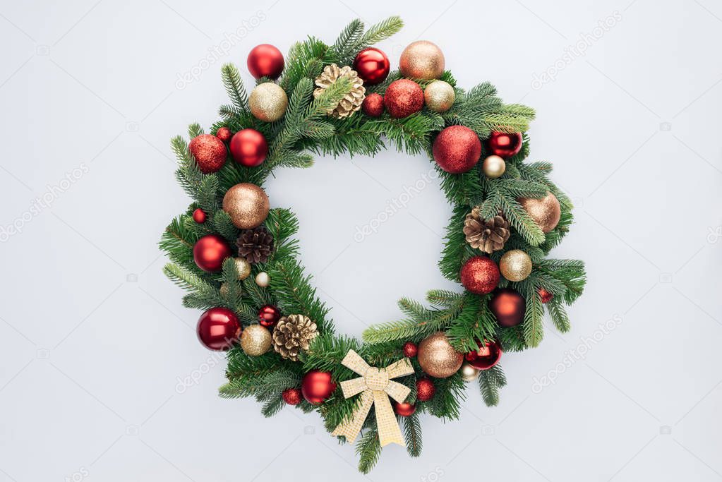 top view of decorative festive wreath with red and golden christmas toys isolated on white