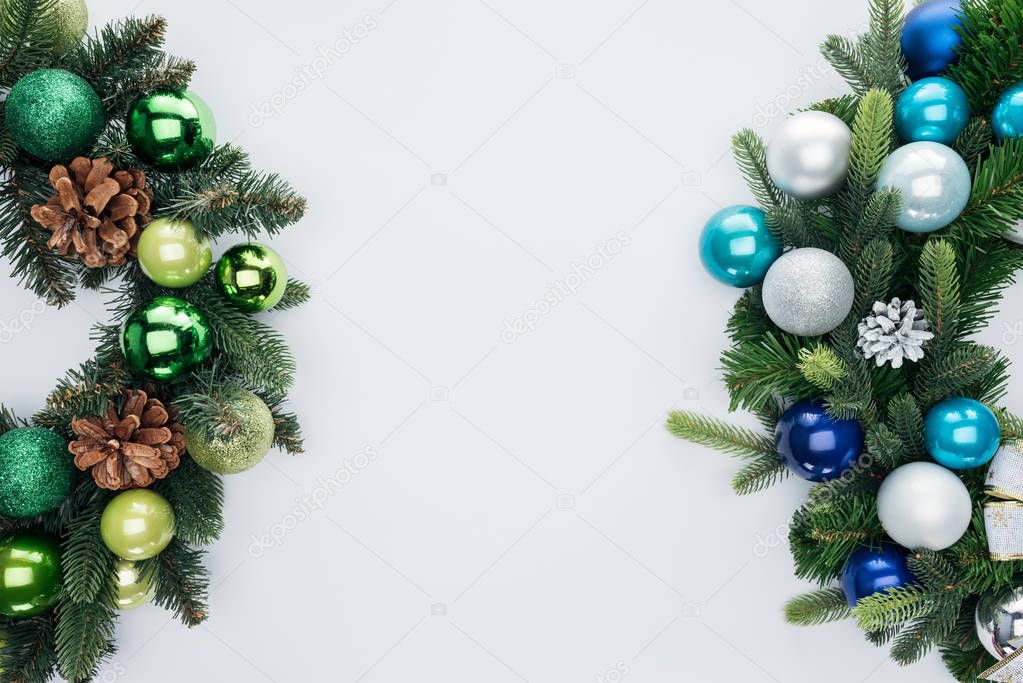 top view of pine tree wreathes with green, blue and silver christmas balls isolated on white